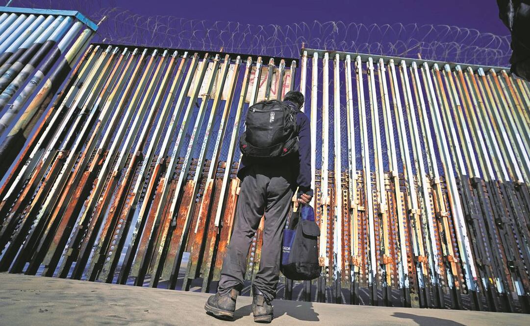 Frente al muro situado a las orillas de Playas de Tijuana, un migrante observa el otro lado de la muralla, hacia Estados Unidos. Foto: AP