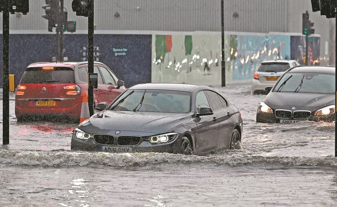 Conductores intentaban ayer alejarse de las zonas inundadas, en el distrito londinense de Nine Elms. Foto: Justin Tallis. AFP