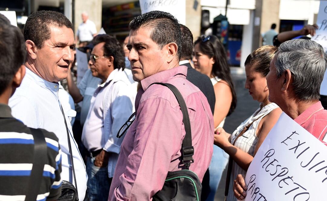El secretario de Desarrollo Social del estado de Morelos, Gilberto Alcalá (c), y el empresario Jesús García (i), conversan momentos antes de que agresores dispararan al empresario, quien perdió la vida. Foto: EFE