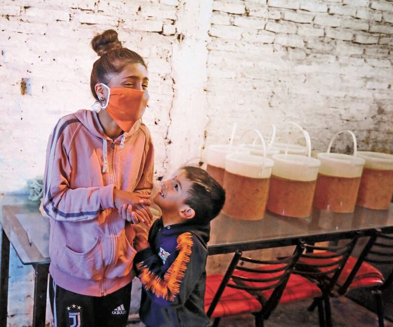 Niños esperan comida repartida por soldados del ejército en la localidad de Rafael Castillo, en Argentina. Debido a la cuarentena, millones de menores se quedaron sin alimentos escolares. JUAN IGNACIO RONCORONI. EFE