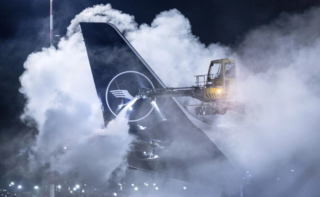 Operarios retiran el hielo de un avión de Lufthansa en el aeropuerto de Fráncfort, Alemania. Foto: AP