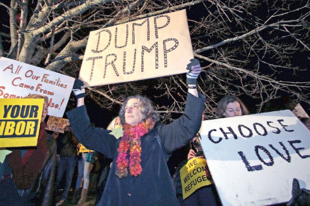 Manifestantes expresan su rechazo a las declaraciones de Donald Trump contra los migrantes y musulmanes, afuera del lugar donde el aspirante presidencial republicano celebraba un acto de campaña, ayer, en Portsmouth, New Hampshire (CHARLES KRUPA. AP)
