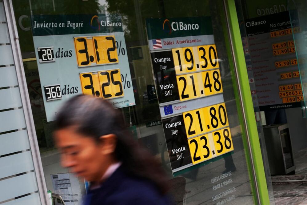 A woman walks pass a board displaying the exchange rate for Mexican peso and U.S. dollars in a Bank in Mexico City, Mexico, November 11, 2016. REUTERS/Carlos Jasso