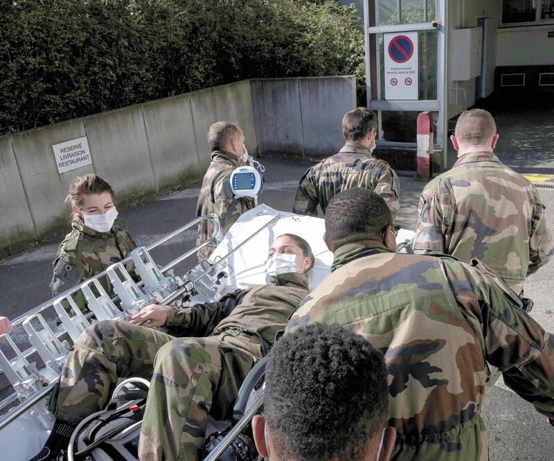 Soldados franceses transportan a una compañera en un centro médico, afuera del Hospital Emile Muller, en Mulhouse. Francia es el tercer país que ha registrado más muertes en el mundo en las últimas 24 horas, con 231. SEBASTIEN BOZON. REUTERS