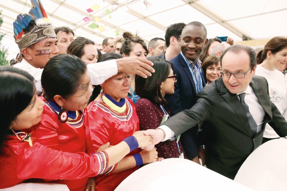 El presidente francés, François Hollande, saluda a indígenas ecuatorianos en el área Generaciones Climáticas, durante la jornada de ayer de la COP21, en Le Bourget, al norte de París