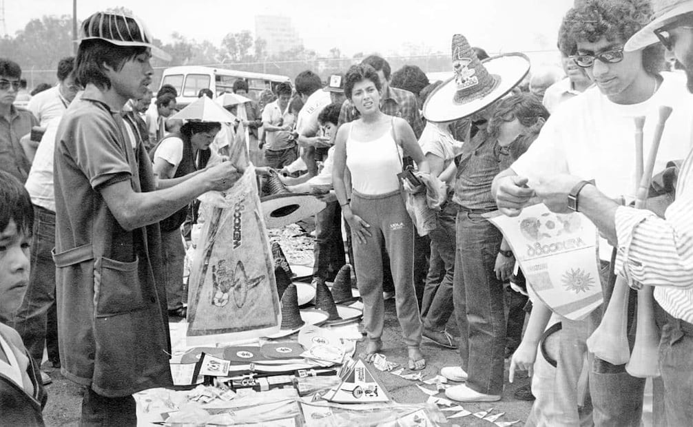 Venta de banderines, carteles y sombreros a las afueras del Estadio Azteca, durante el mundial México 86. El día de la inauguración vendedores ambulantes de productos y comida llegaron a la explanada del Coloso de Santa Úrsula desde la madrugada del 31 de mayo, buscando el mejor lugar para instalarse. Foto: René Rozzainizz/Archivo EL UNIVERSAL.