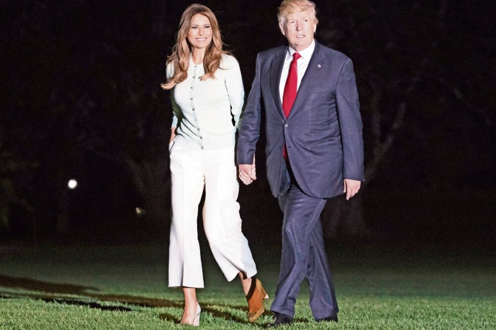 El presidente Donald Trump y la primera dama Melania, al descender del helicóptero presidencial en los jardines de la Casa Blanca, en Washington (CAROLYN KASTER. AP)