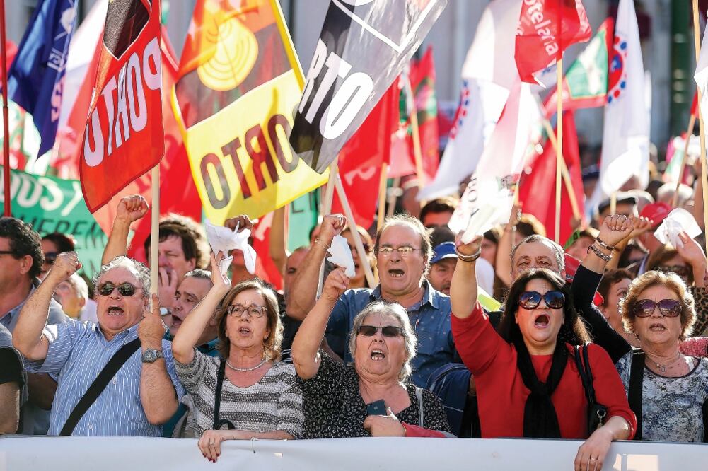 Manifestantes expresan este martes, ante la escalinata del Parlamento, su rechazo a la caída del Ejecutivo portugués (TIAGO PETINGA. EFE)