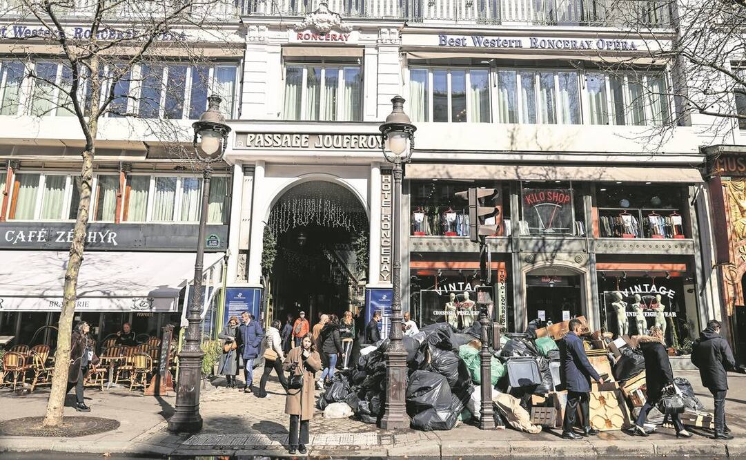 Personas caminan junto a botes de basura en París. Foto: Mohammed Badra. EFE
