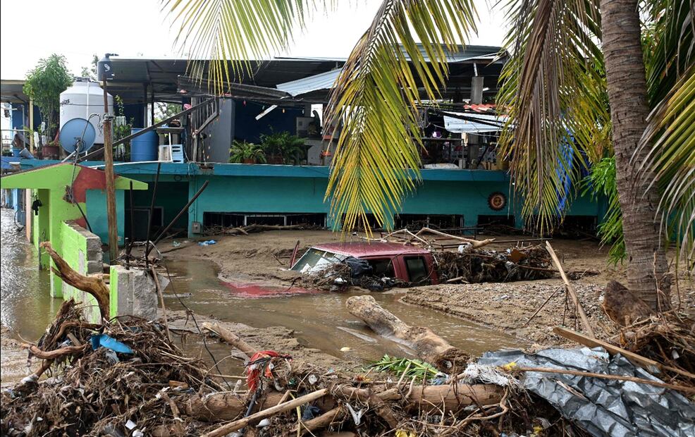 Un automóvil se encuentra sumergido en una de las colonias del puerto de Acapulco que permanecen anegadas, tras el paso hace una semana del huracán John por Guerrero. Foto: AFP