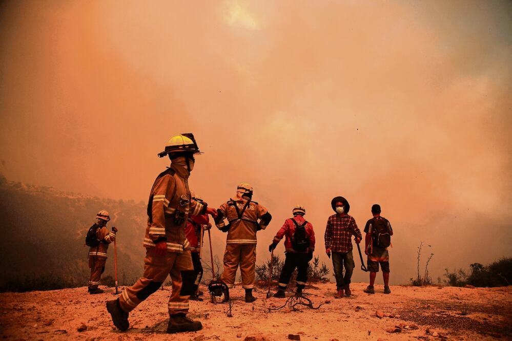Los bomberos trabajan en la zona de un incendio forestal en las colinas de la comuna de Quilpé, región de Valparaíso, el sábado pasado. Foto: Javier Torres / AFP