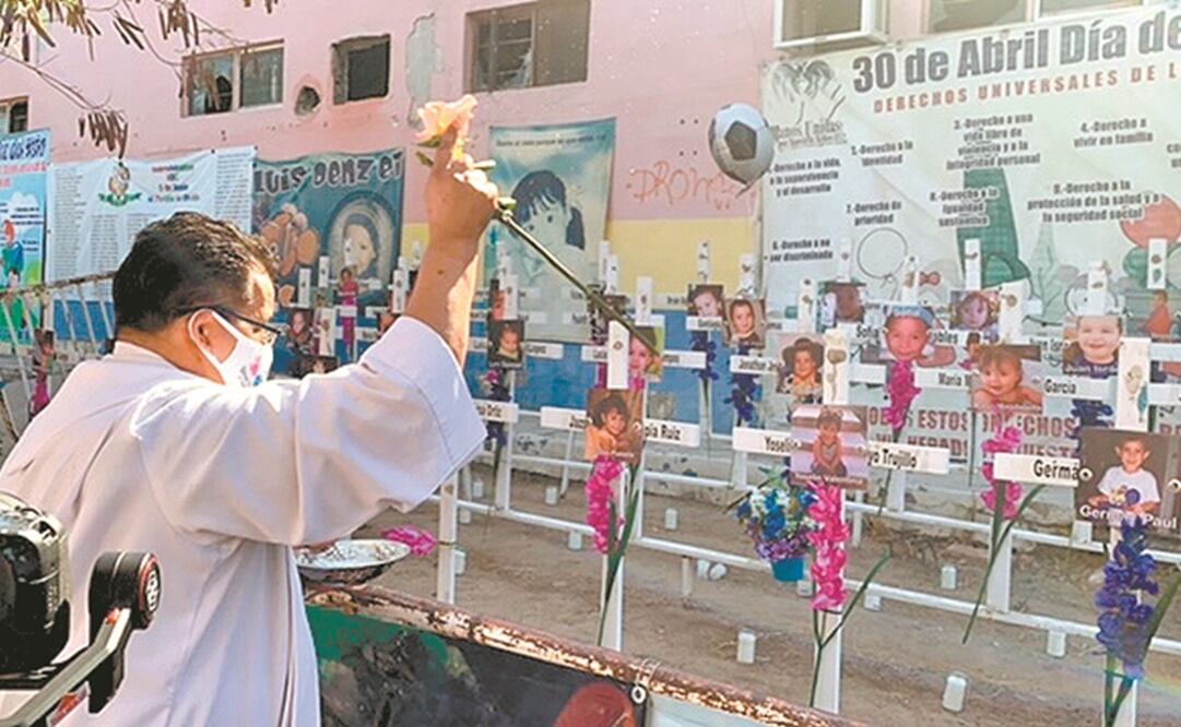 El sacerdote Martín Peralta roció con agua bendita las 49 cruces con las fotos de los niños fallecidos en el incendio de la Guardería ABC, en Sonora. Foto: Amalia Escobar. EL UNIVERSAL