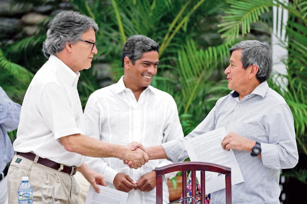 Gustavo Bell (izq.), negociador en jefe del gobierno colombiano, estrecha la mano de Pablo Beltrán, del ELN, tras dar una declaración en La Habana. (TOMAS BRAVO. REUTERS)