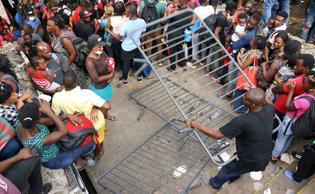 Migrantes rompen el cerco de seguridad durante una manifestación frente a la Comar. Foto: EFE