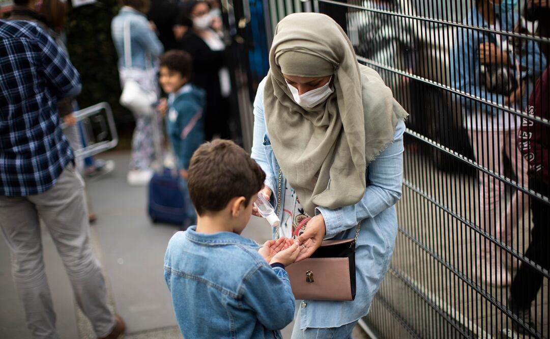 Imagen ilustrativa de una mujer dando gel antibacterial a un niño. Foto: AP, Francisco Seco, archivo