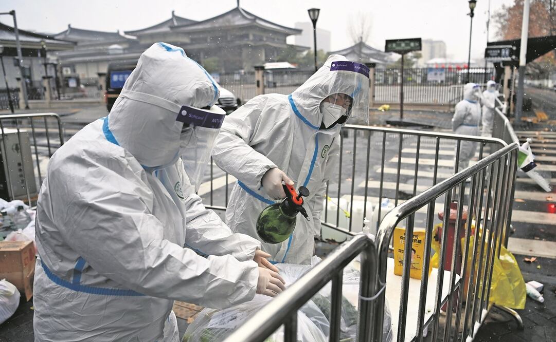 Personal desinfecta una zona bajo cuarentena en la ciudad de Xian, epicentro del último rebrote de coronavirus en China. Foto: AP 