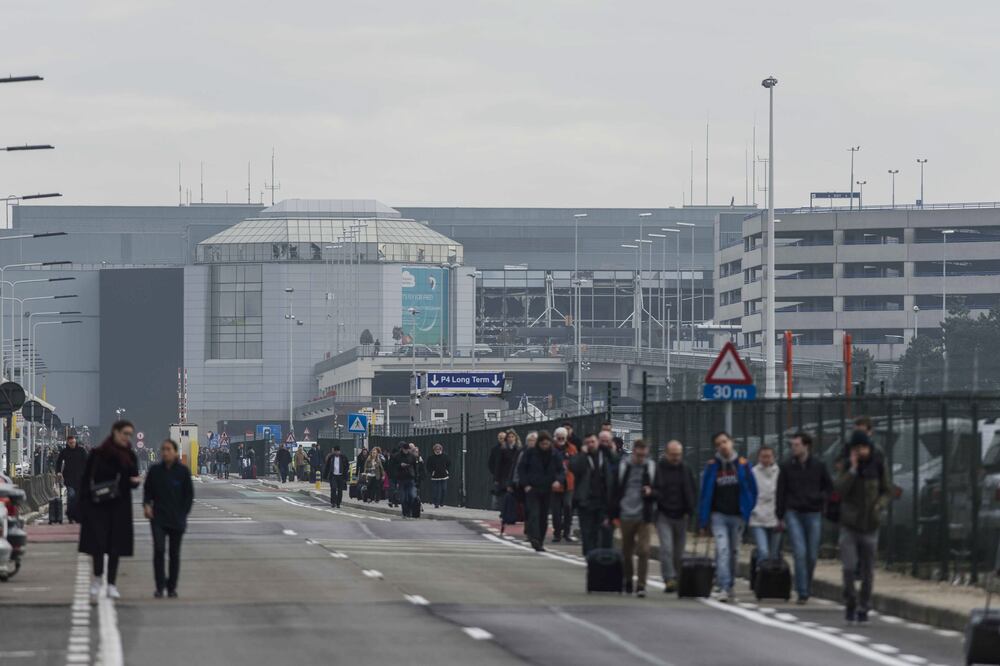 Pasajeros y trabajadores evacúan el edificio de la terminal tras registrarse explosiones en el aeropuerto internacional de Zaventem, cerca de Bruselas (EFE)