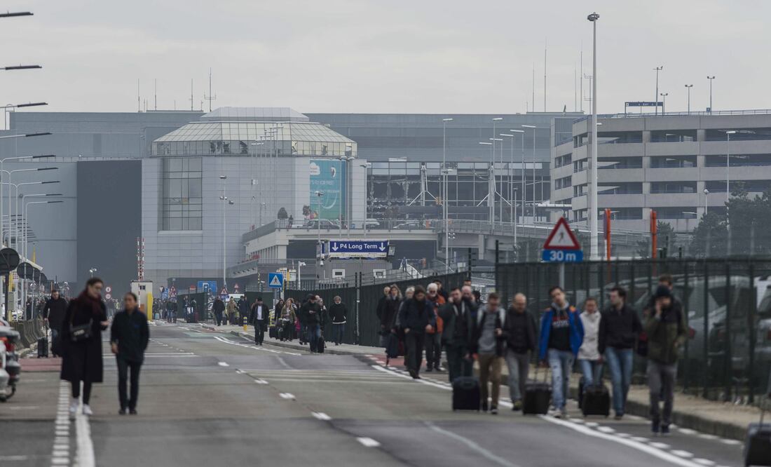 Pasajeros y trabajadores evacúan el edificio de la terminal tras registrarse explosiones en el aeropuerto internacional de Zaventem, cerca de Bruselas (EFE)