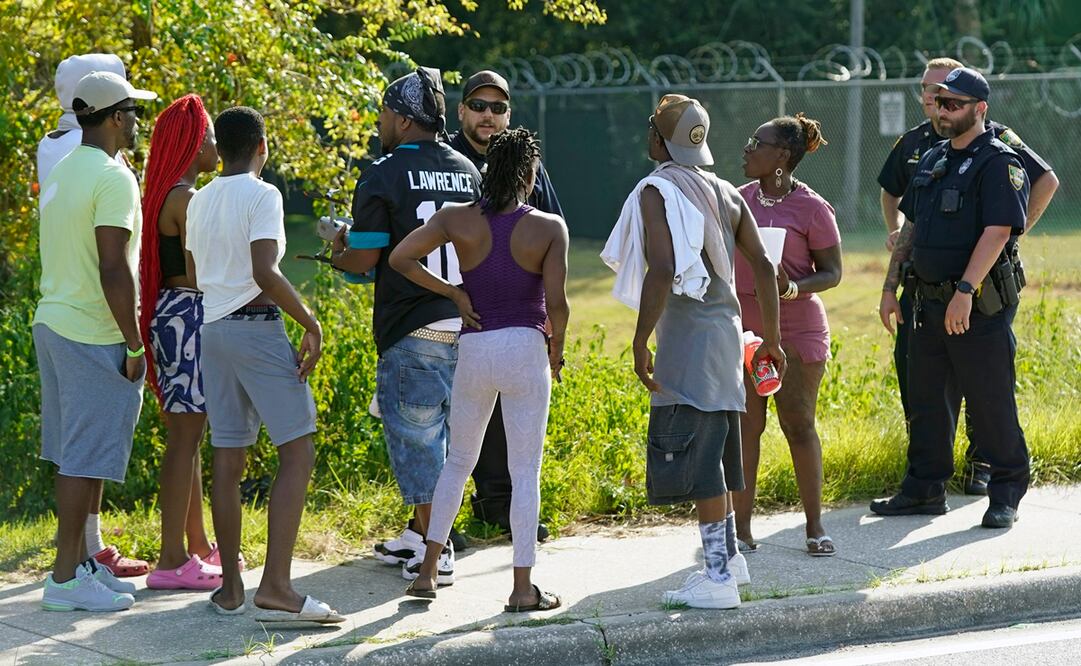 Los residentes hablan con agentes de Jacksonville cerca de la escena de un tiroteo masivo en una tienda Dollar General, el sábado 26 de agosto. Foto: AP