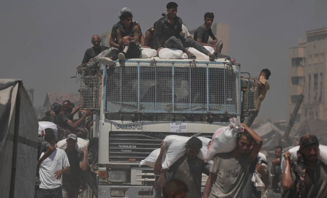 Palestinos cargan sacos de harina descargados de un convoy de ayuda humanitaria que llegó a la ciudad de Gaza desde el norte de la Franja de Gaza. Foto: AP
