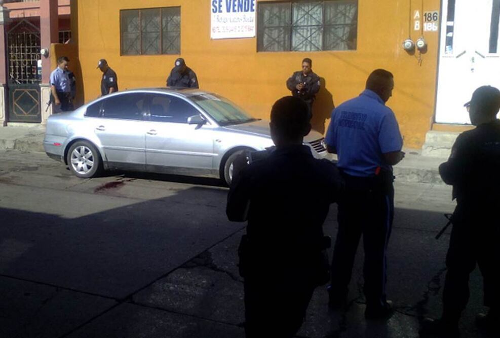 Agentes municipales vigilan el vehículo donde fueron localizados los cuerpos. (Foto: EFE)
