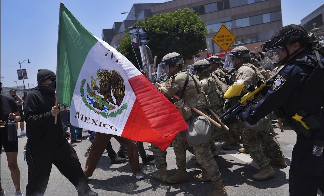 Manifestantes se enfrentan con policías antidisturbios en el centro de Los Ángeles, el domingo 8 de junio de 2025, tras las redadas migratorias por autoridades federales de inmigración. Foto: AP