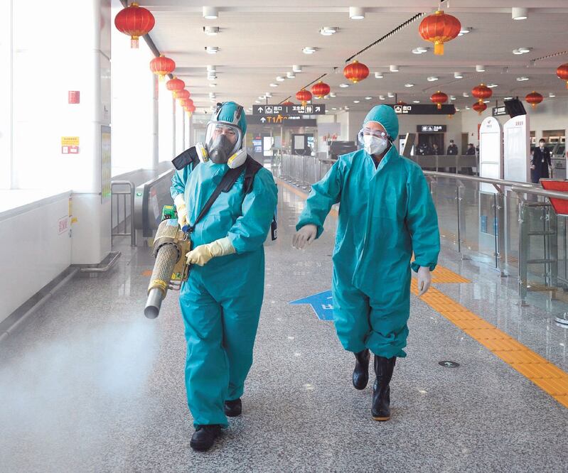 Miembros del equipo Rescate del Cielo Azul de Changsha, al rociar desinfectante en una estación de trenes en Hunan, China. Foto: CHEN ZHENHAI. XINHUA