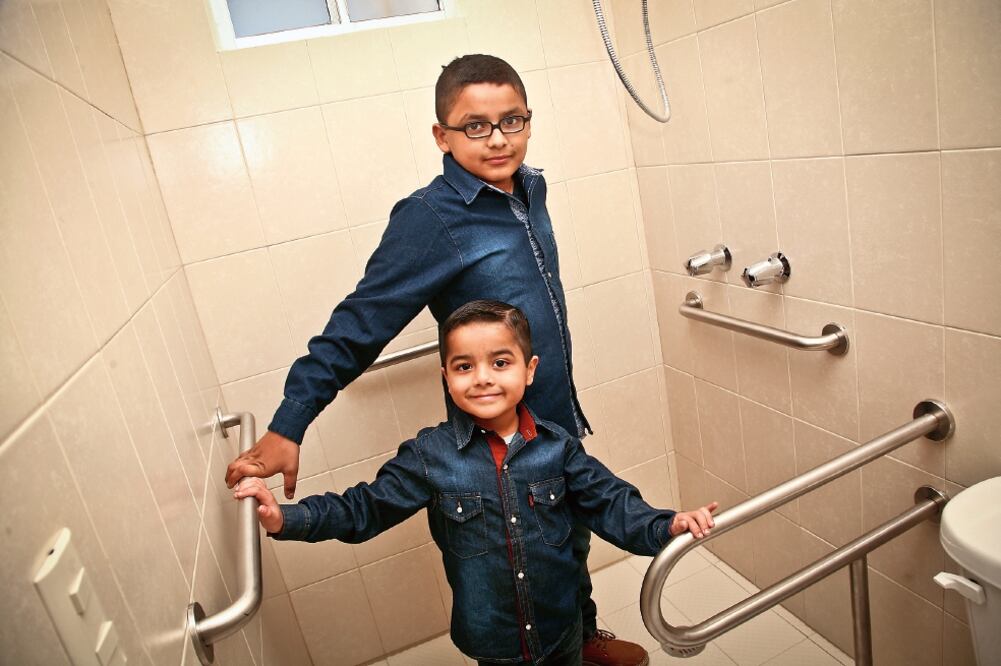 Zaith, de 11 años, señala que el baño de su nueva vivienda le brinda mayor seguridad a su hermano menor Paul, quien nació con el síndrome llamado artrogriposis múltiple congénita (ROBERTO ARMOCIDA)