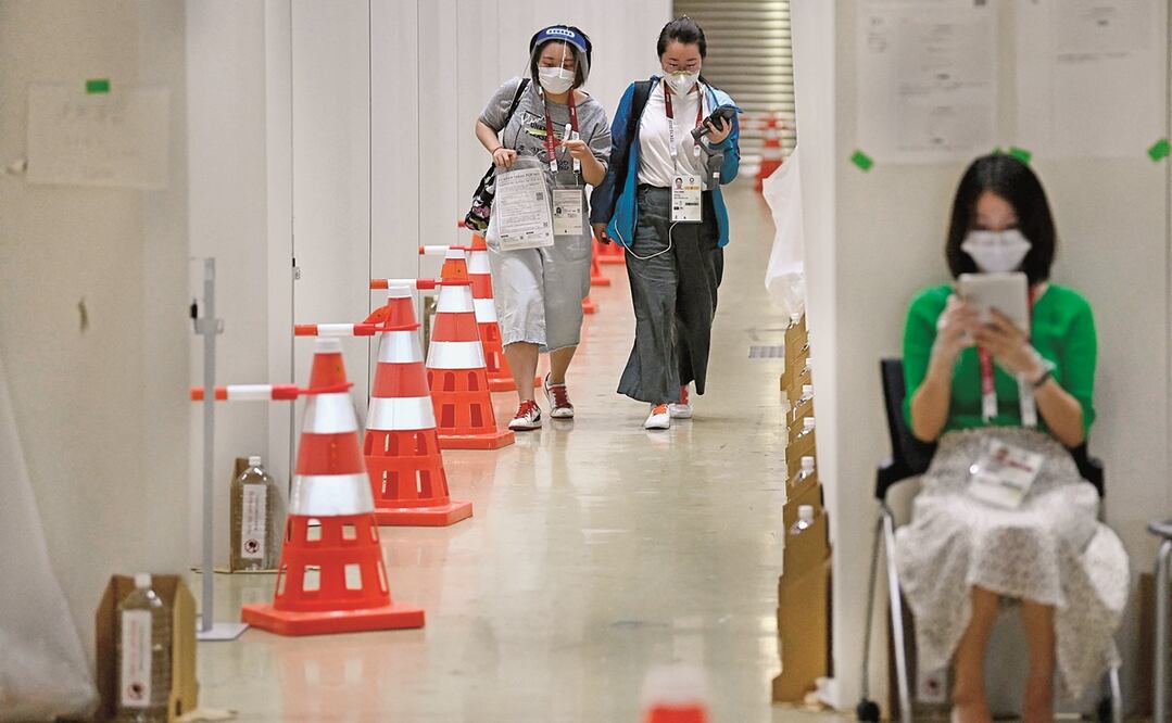Una periodista con su muestra diaria de saliva para la prueba de PCR en el centro de medios, antes de la inauguración de los Juegos Olímpicos de Tokio 2020. Foto: FRANCK FIFE. AFP