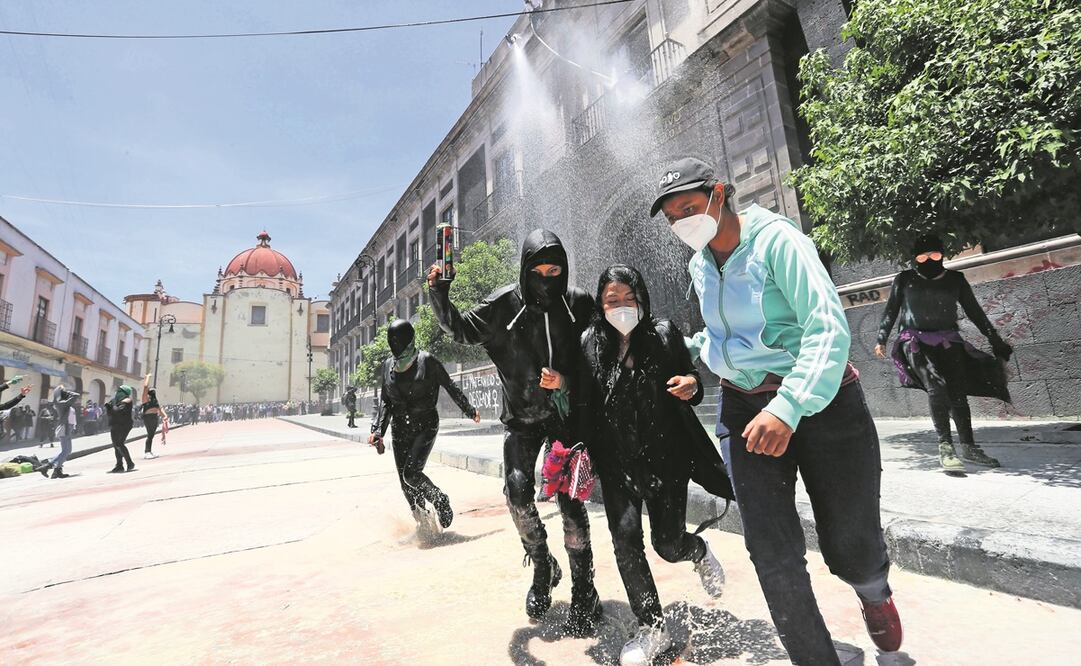 Al vandalizar la fachada del Congreso estatal, los grupos feministas fueron dispersados con gas lacrimógeno que los trabajadores de la 60 Legislatura lanzaron. Fotos: Jorge Alvarado. EL UNIVERSAL