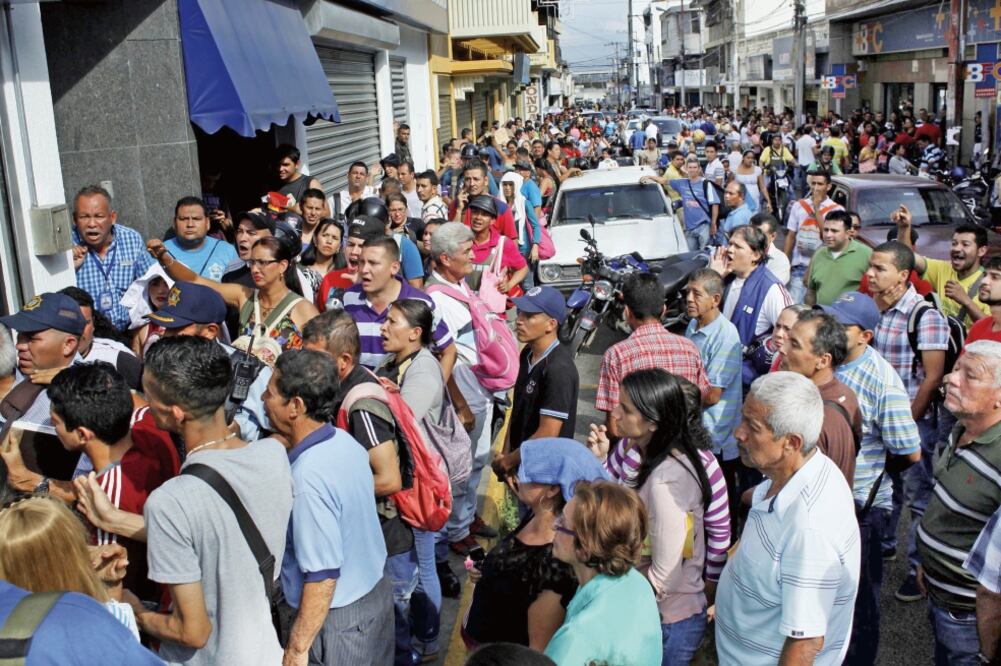 Venezolanos esperan en la calle a poder entrar a un banco en San Antonio del Tachira, para deshacerse de sus billetes de 100 bolívares. (CARLOS EDUARDO RAMÍREZ. REUTERS)