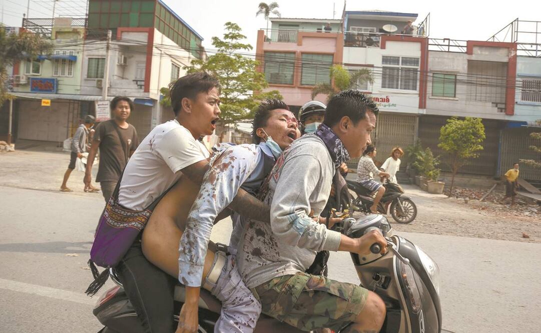 Manifestantes auxilian a un compañero herido, en Mandalay. Foto: EFE