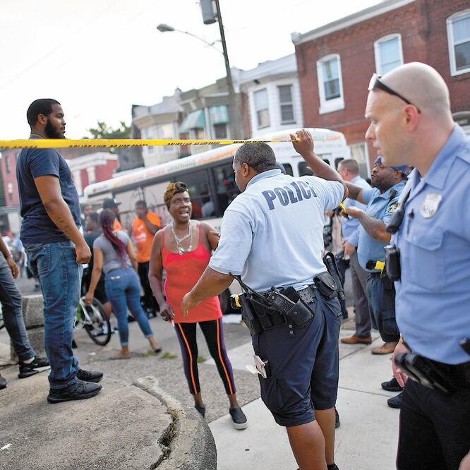 Oficiales piden a los habitantes de Nicetown que retrocedan, cerca del lugar donde se reportó un tiroteo en Filadelfia, Pennsylvania. MARK MAKELA. AFP