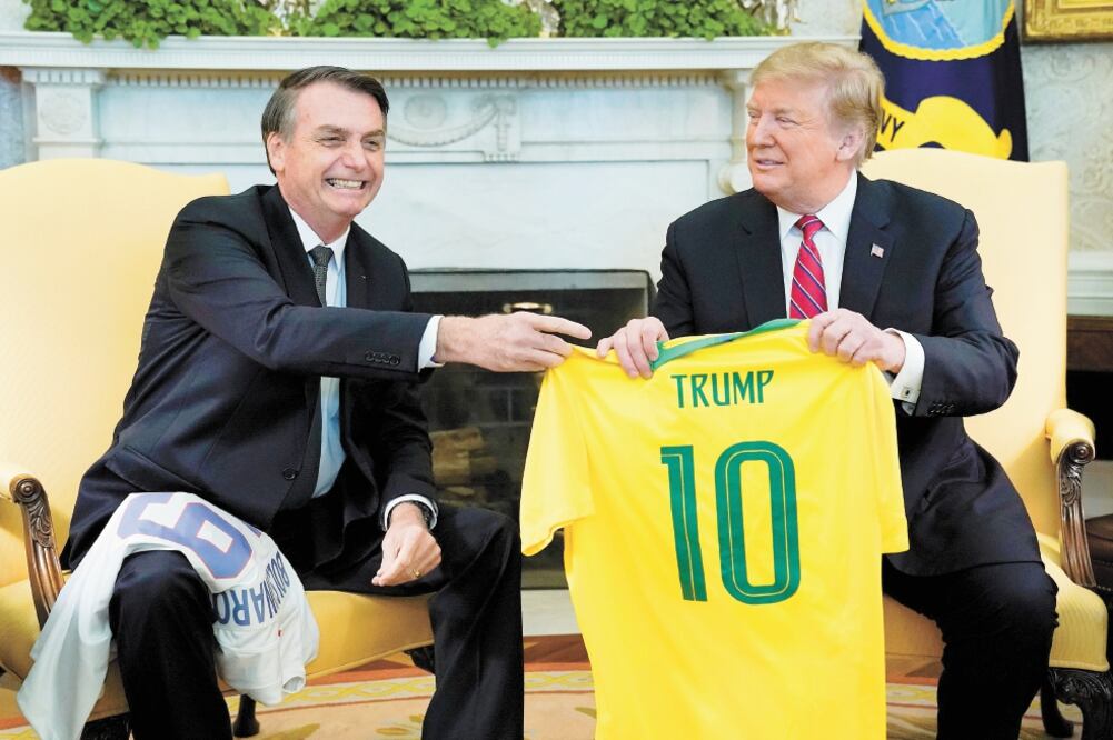 Los presidentes brasileño, Jair Bolsonaro, y estadounidense, Donald Trump, intercambiaron ayer camisetas de futbol en su reunión en la Casa Blanca. Foto: KEVIN LAMARQUE. REUTERS