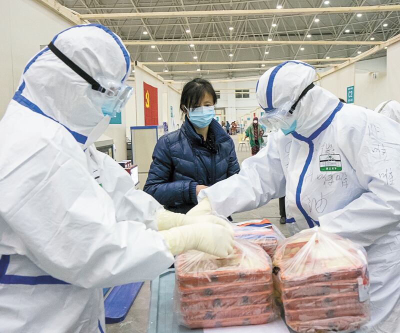 Las autoridades sanitarias distribuyeron comida en el Wuhan Livingroom, centro convertido en hospital improvisado, en Wuhan, provincia de Hubei, en el centro de China. Foto: XIONG QI. REUTERS 