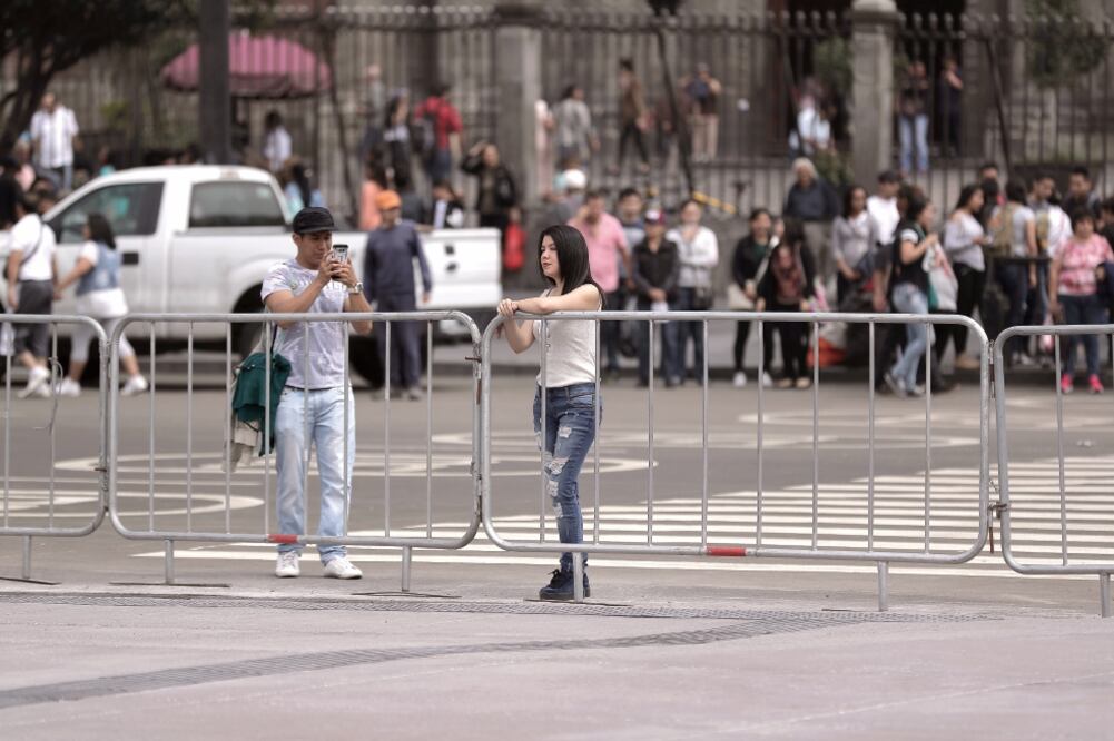 Algunas personas acudieron a la explanada del Zócalo para presenciar el trabajo final de las obras de remozamiento y tomar fotos (ESPECIAL)
