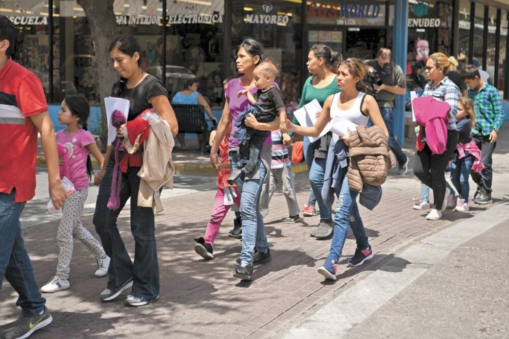 Inmigrantes caminan desde una estación de autobús a un albergue de Catholic Charities, tras ser liberados de un centro migratorio, en McAllen. Foto: LOREN ELLIOTT. REUTERS