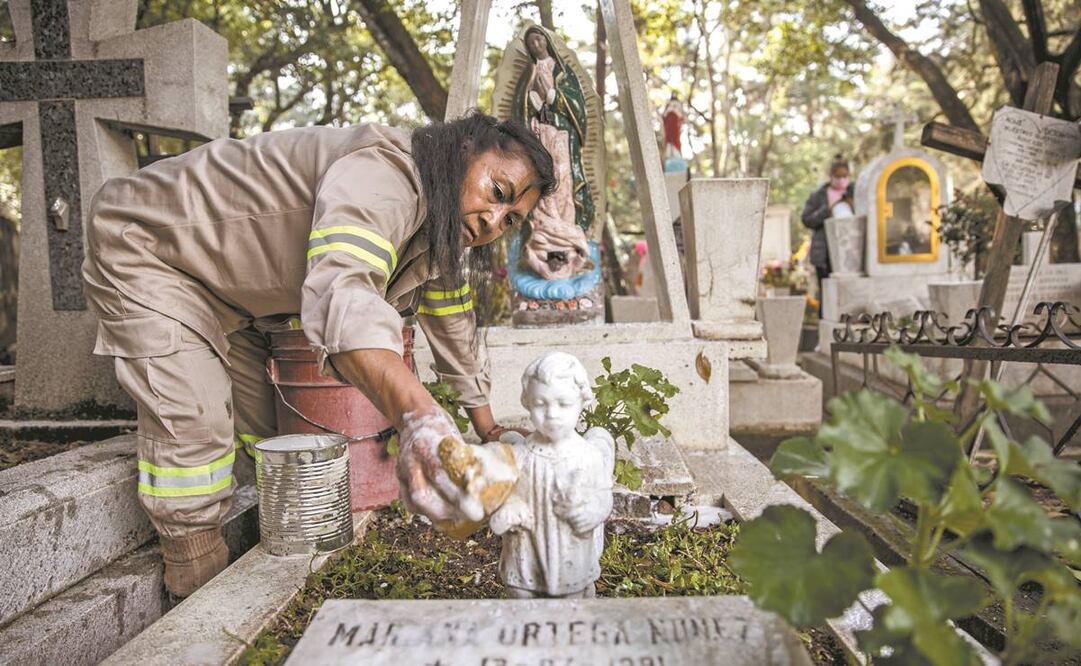 Doña Guadalupe, sepulturera en el panteón San Rafael, limpia una de las tumbas; señala que disfruta ver el sitio lleno de gente.Foto: Germán Espinosa/ EL UNIVERSAL