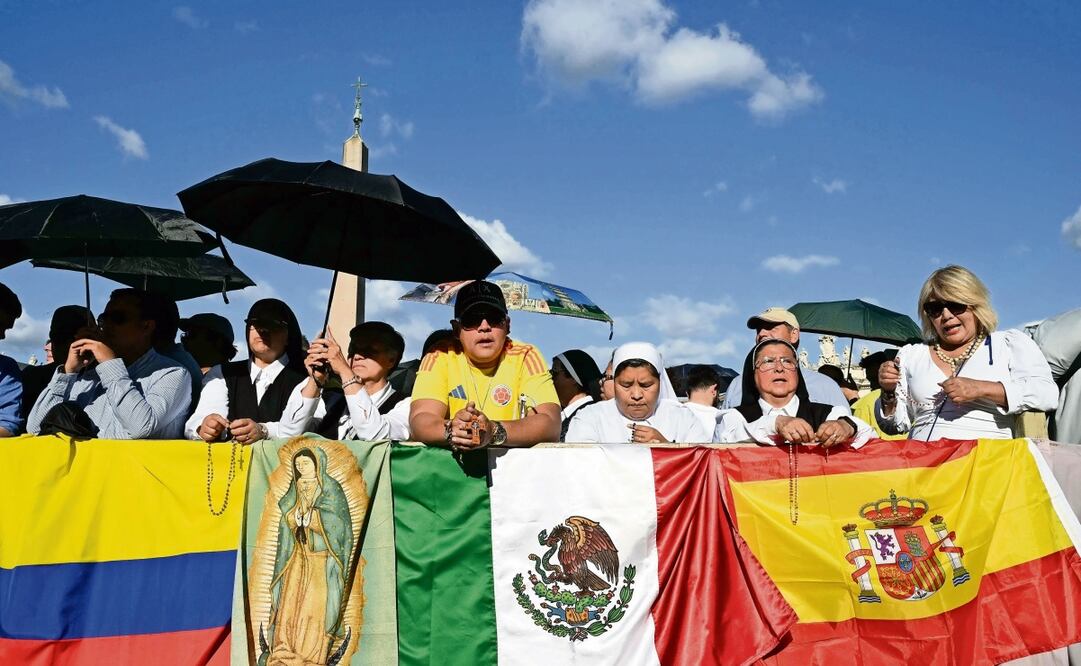Personas junto a banderas de Colombia, México y España se reunieron en la Plaza de San Pedro el segundo día del cónclave en el Vaticano. Foto: Stefano Rellandini / AFP)