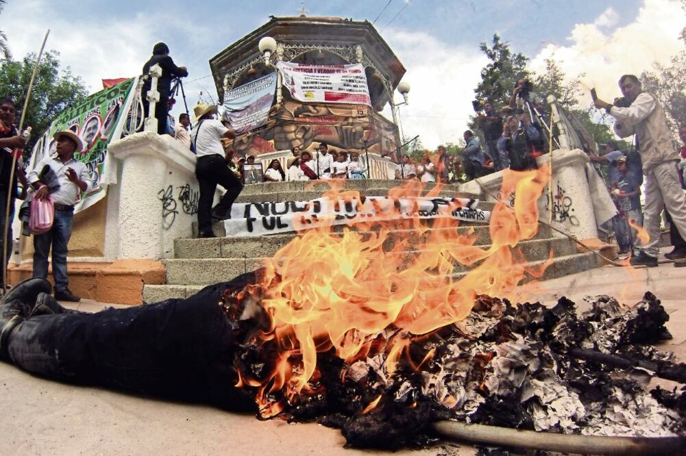 Durante el mitin, integrantes de la CNTE quemaron la figura de un mono vestido como policía en el parque principal de Nochixtlán (EDWIN HERNÁNDEZ. EL UNIVERSAL)