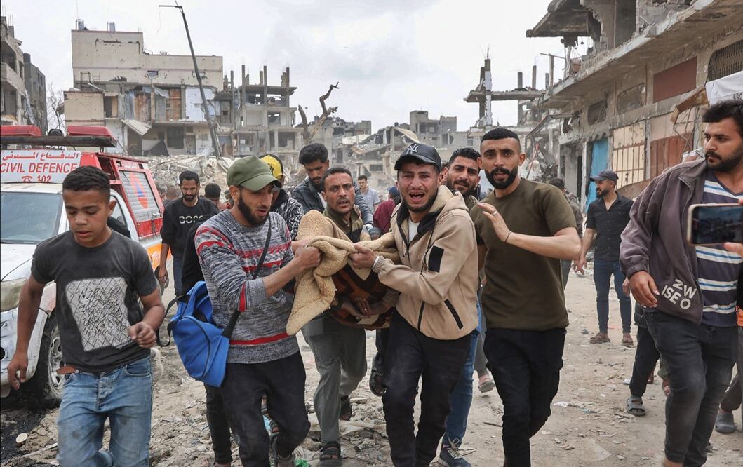 Palestinos llevan un herido en el lugar de un ataque israelí contra una zona residencial del barrio de Shujaiya, en la Ciudad de Gaza, el 9 de abril de 2025. Foto: AFP
