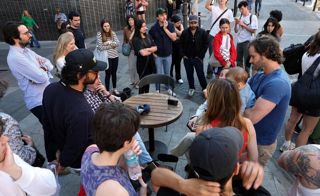 Españoles escuchan la radio durante el apagón de este lunes, en Madrid. FOTO: THOMAS COEX. AFP