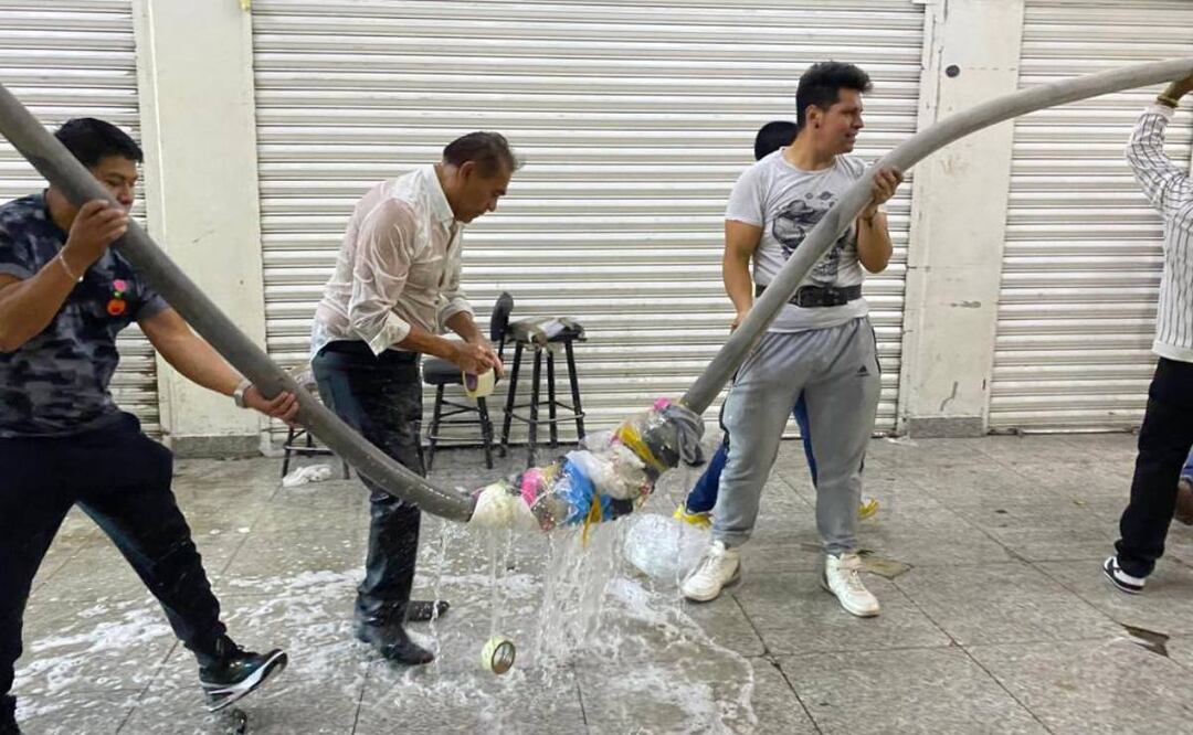Los locatarios y vecinos comenzaron a ayudar al cuerpo de bomberos realizando largas cadenas humanas para cargar las mangueras. Foto: Valente Rosas/El Universal