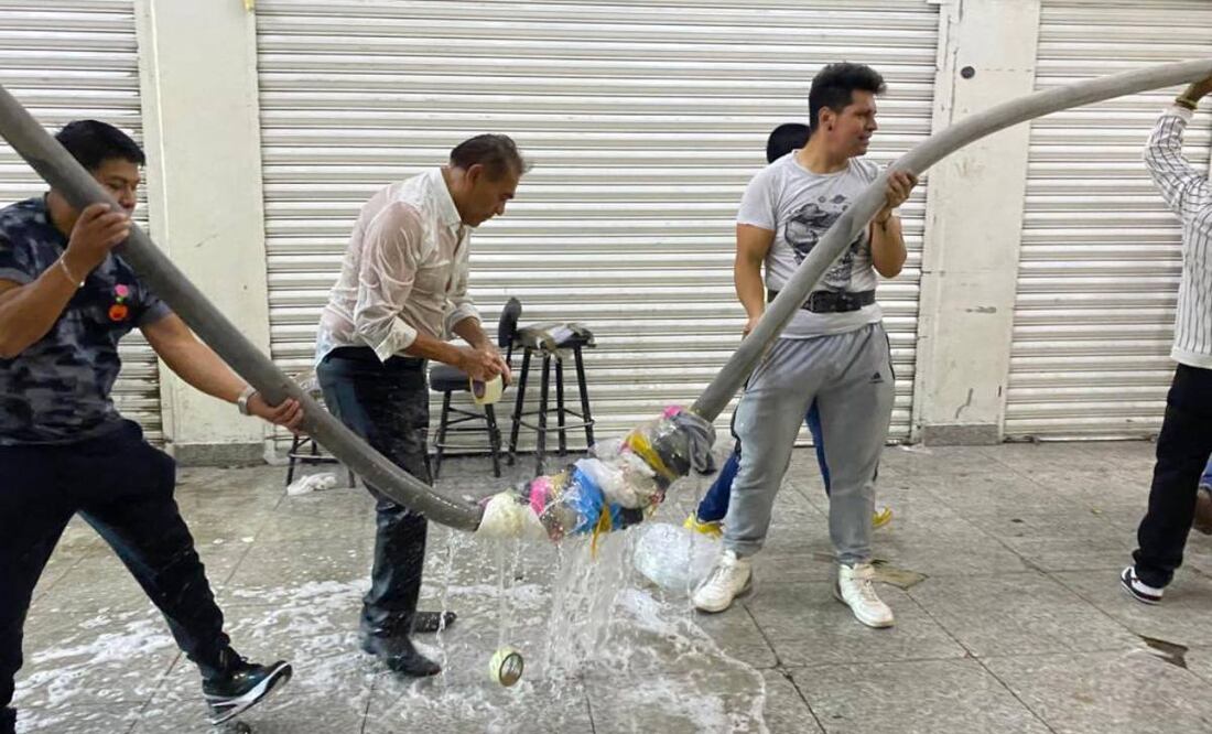 Los locatarios y vecinos comenzaron a ayudar al cuerpo de bomberos realizando largas cadenas humanas para cargar las mangueras. Foto: Valente Rosas/El Universal