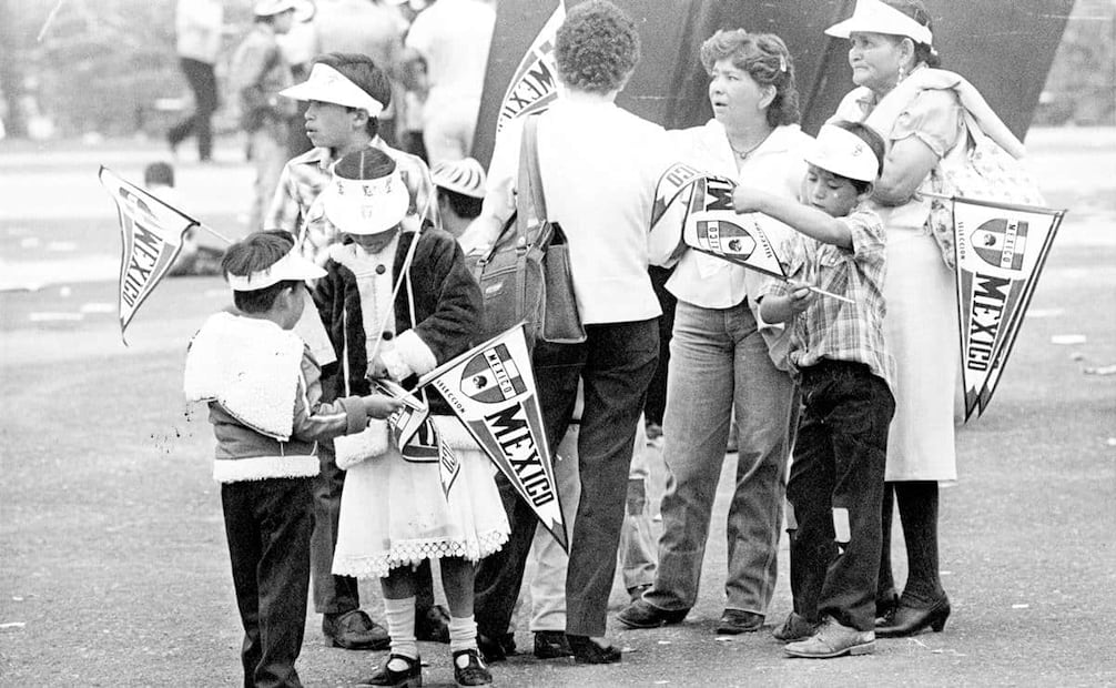 Familia de aficionados cargados con banderines y viseras con motivos del mundial México 86. En tiendas oficiales, una sencilla gorra de poliéster con el logo de México 86 llegó a costar mil 450 pesos de aquel entonces. Foto: Gildardo Solís/Archivo EL UNIVERSAL.