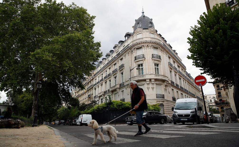 En esta imagen del 13 de agosto de 2019, un hombre pasea al perro ante un edificio de apartamentos propiedad de Jeffrey Epstein en París. Foto: AP