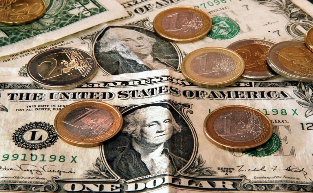 Euro coins are seen next to U.S. Dollar bills - Photo: Michael Probst/AP