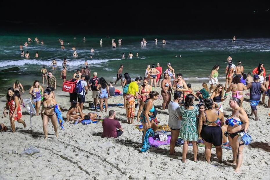 Las personas se bañan a la noche en la playa de Arpoador en Río de Janeiro por las altas temperaturas. Foto: EFE