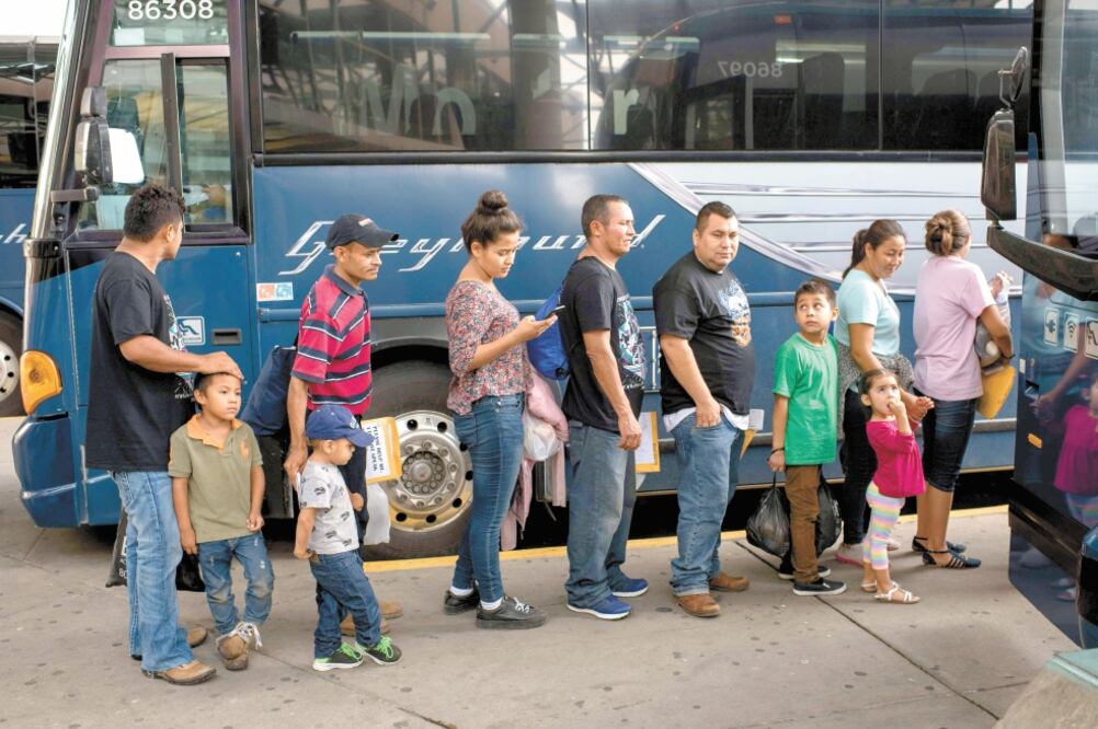 Familias de migrantes centroamericanos liberados esperan un autobús en McAllen, Texas. Foto: LOREN ELLIOTT. AFP