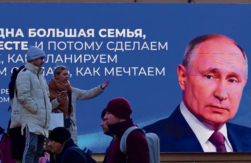 Lugareños junto a una pantalla que muestra al presidente ruso Vladimir Putin y una cita de su discurso ante la Asamblea Federal, en San Petersburgo. Foto: de Olga Maltseva. AFP